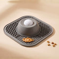 Gray pet mat with a ball and treats on a beige background