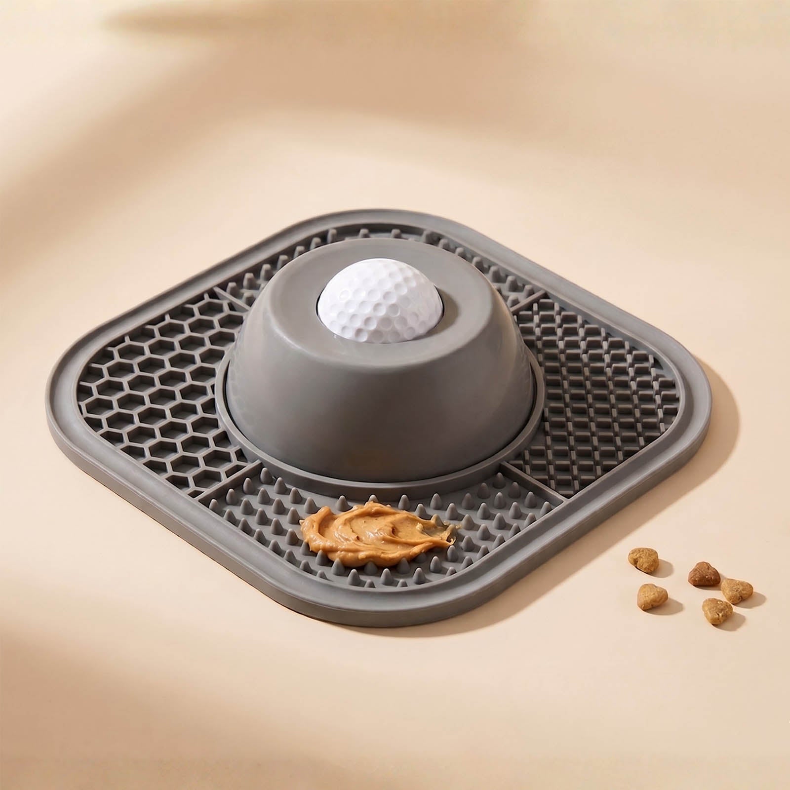 Gray pet mat with a ball and treats on a beige background