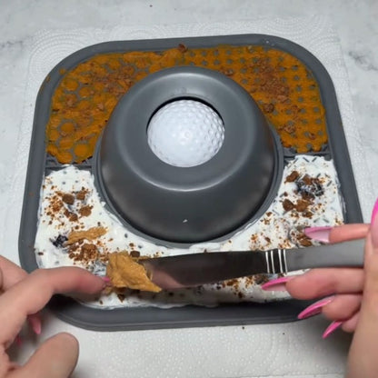 Person using a knife to spread something on a textured surface with a central circular object.